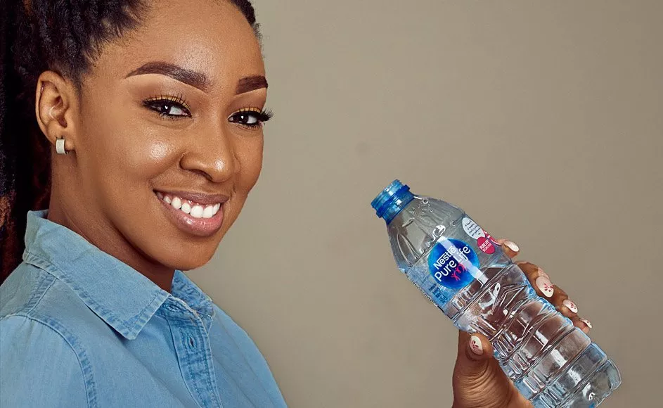 Lady drinking water and a Nestle Pure Life bottle