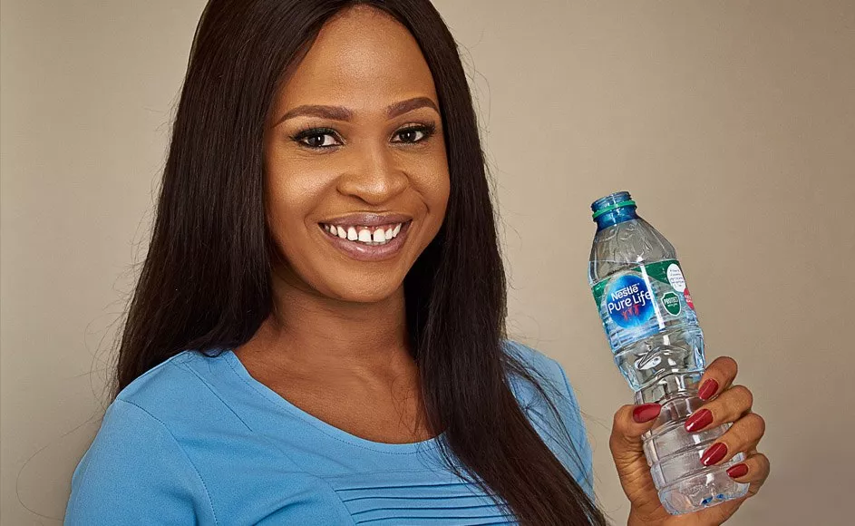 Lady drinking water and a Nestle Pure Life bottle
